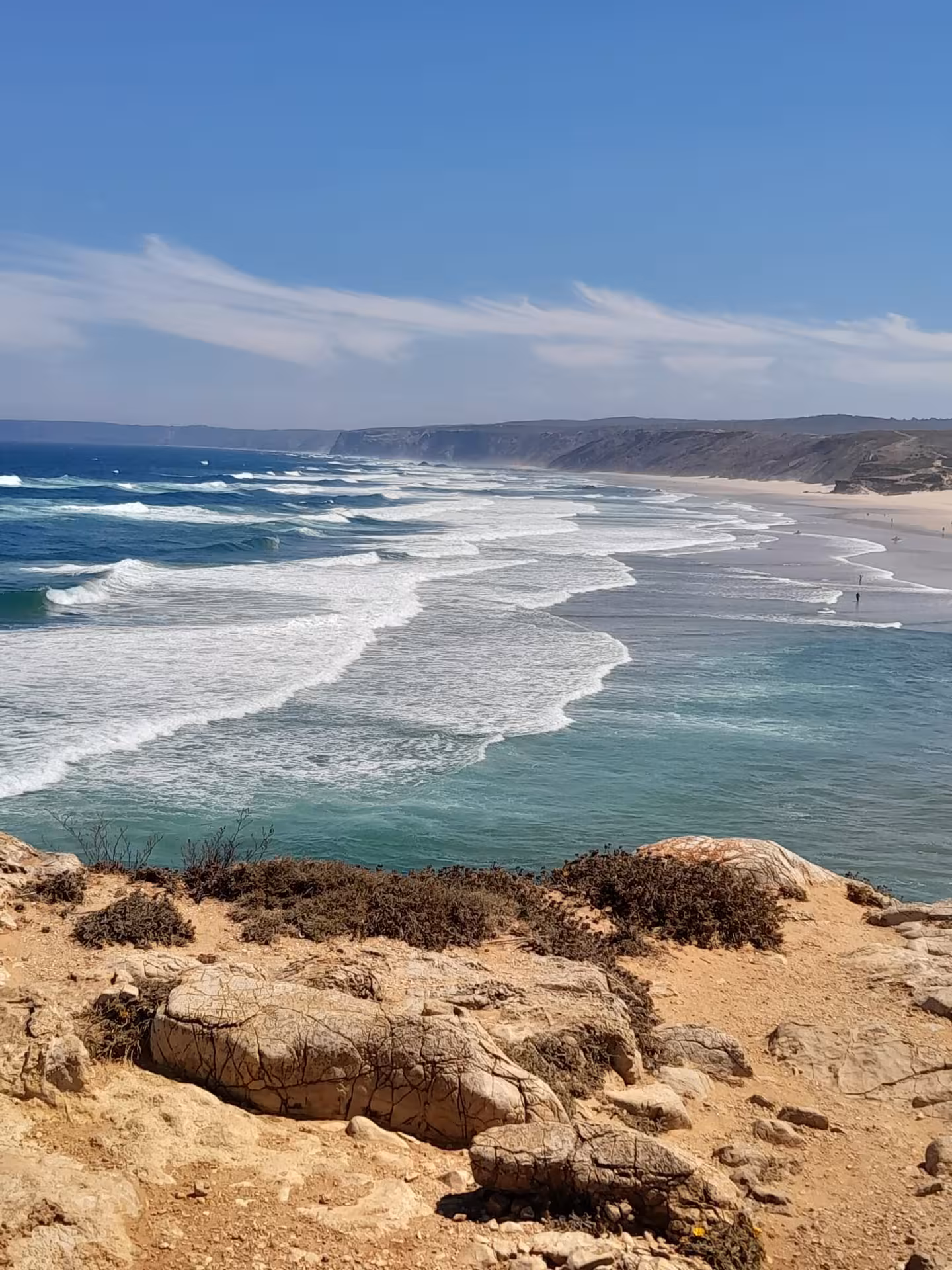 Clifftop view over rolling Atlantic waves and long sandy shoreline on the rugged Algarvian West Coast in Portugal