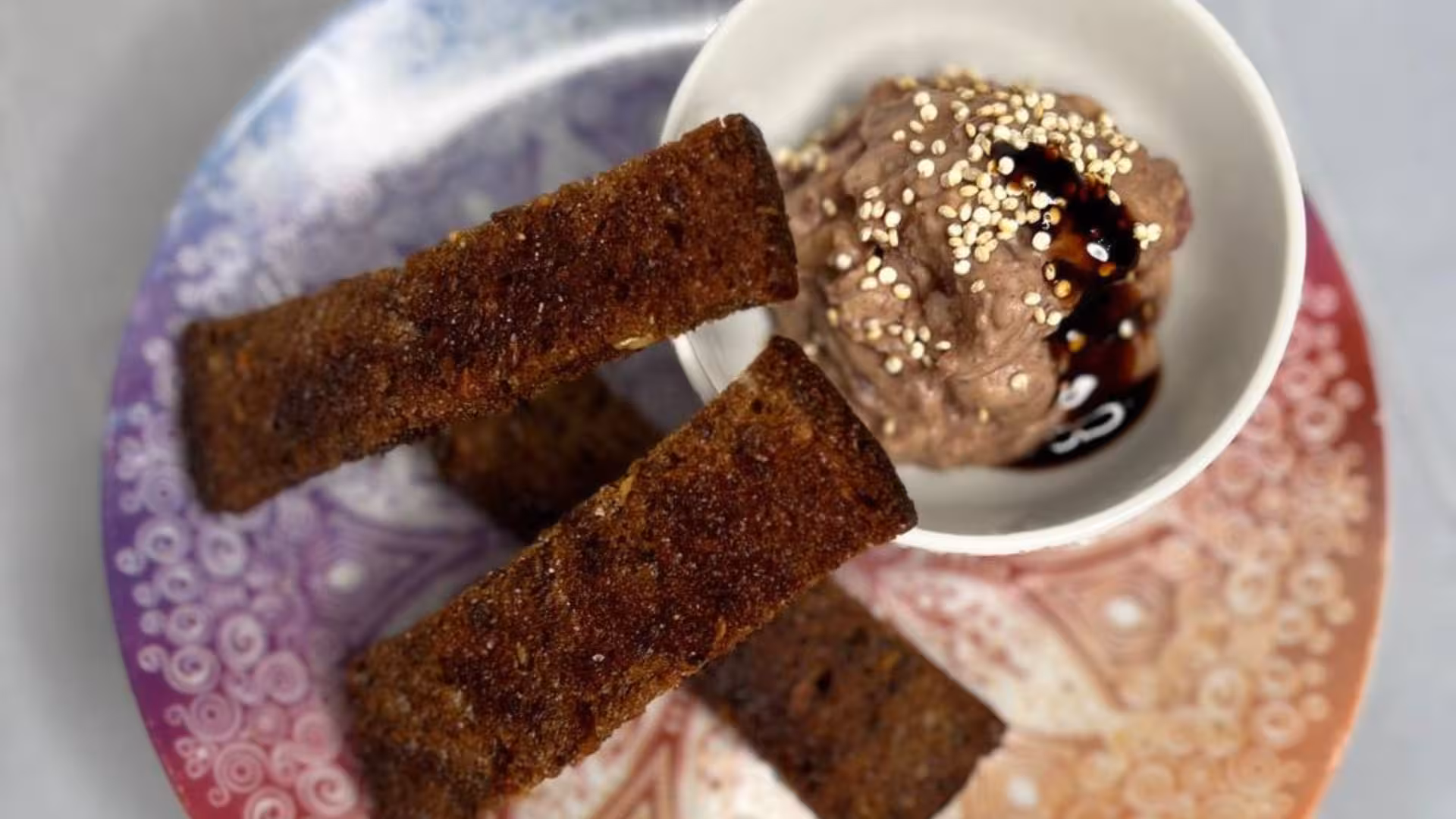 Colorful plate with crispy breadsticks and chocolate dip, part of Alghero animal shelter dining experience.