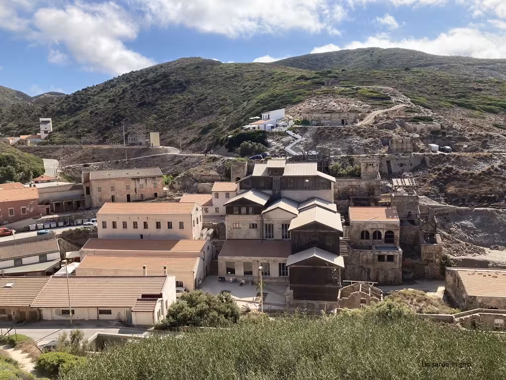 Historic mining village in Argentiera nestled among hills, highlighting Sardinia's cultural heritage on the Alghero tour.