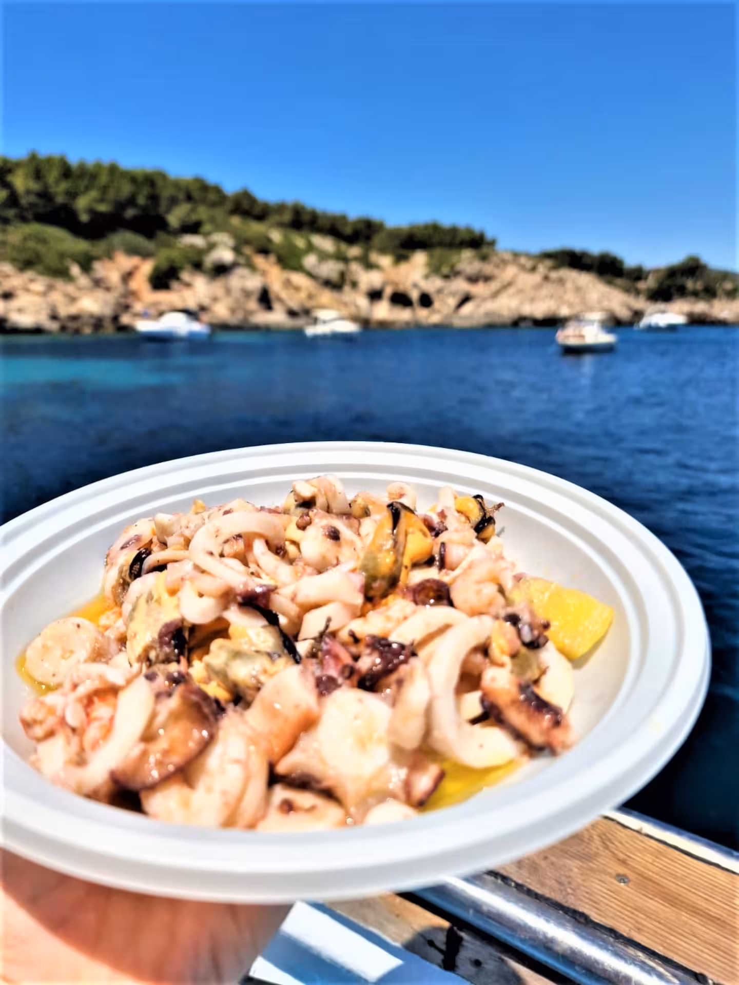 Delicious seafood dish enjoyed on a boat tour in the stunning waters of Capo Caccia near Alghero.