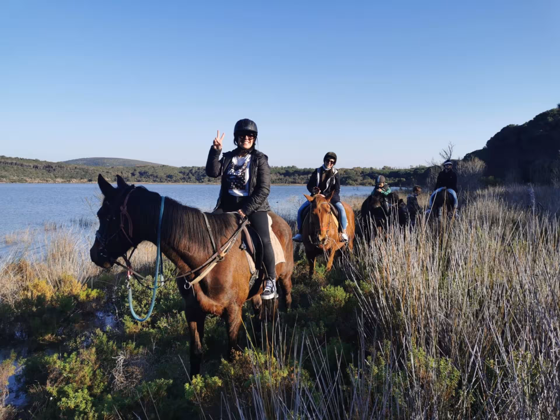Equestrians riding through lush landscapes near Lake Baratz, enjoying a serene Alghero horseback tour.