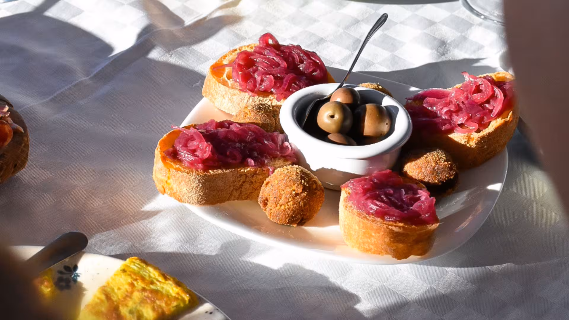 Delicious Italian antipasto plate with olives and bruschetta, ideal for a vineyard aperitif in Alghero.