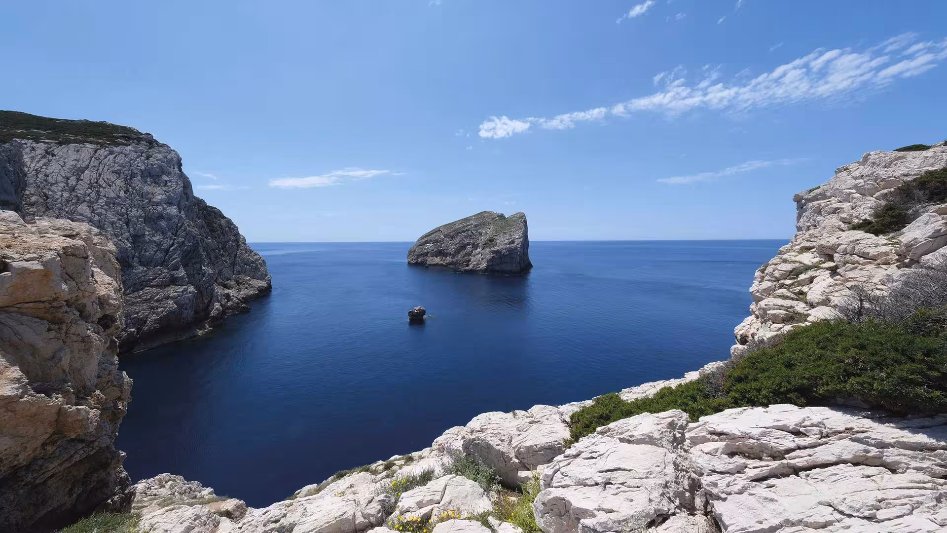 Marvel at the stunning sea cliffs and tranquil waters of Porto Conte Park's coastline in Alghero.