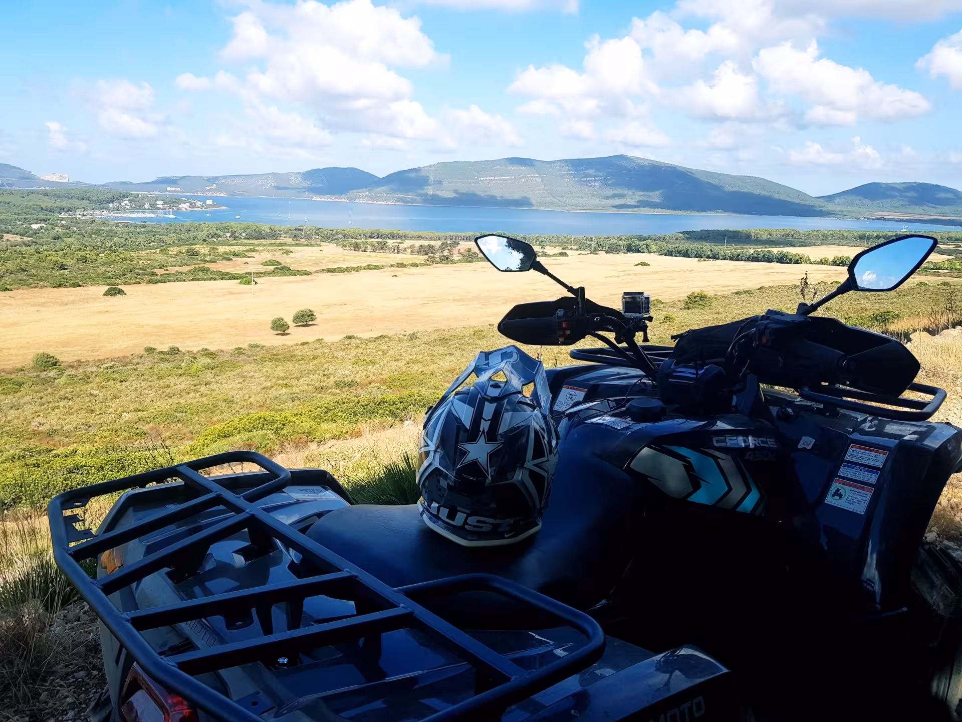Quad bike overlooking Alghero's scenic landscape with rolling hills and clear blue skies on a 4-hour tour.