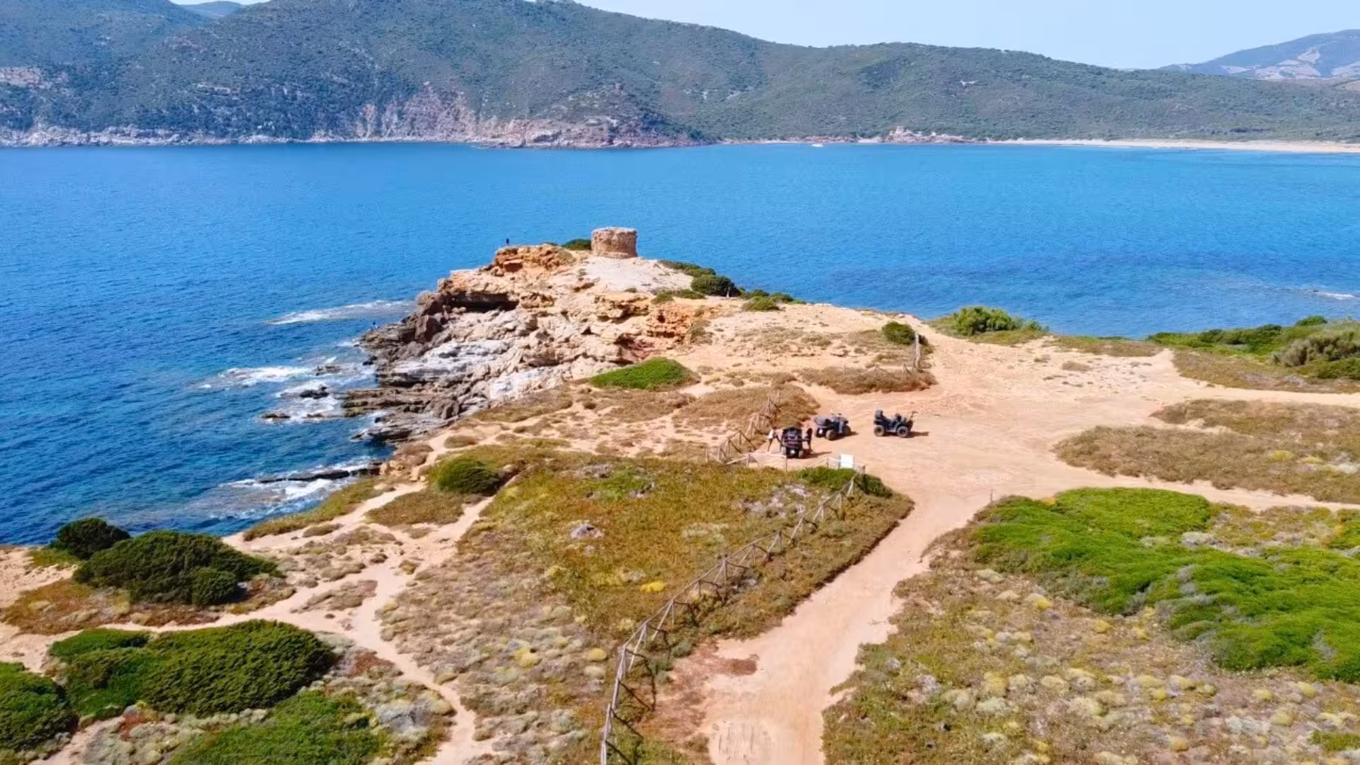 Aerial view of Alghero's rugged coastline on a quad tour, showcasing stunning cliffs and azure waters.