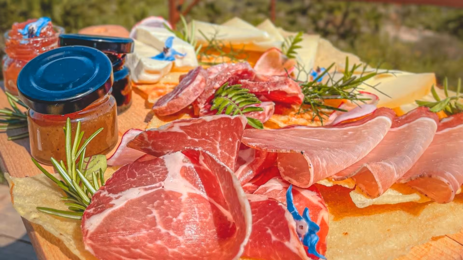 Delicious platter of Italian cured meats, cheeses, and preserves, showcasing local Sardinian flavors in Alghero.