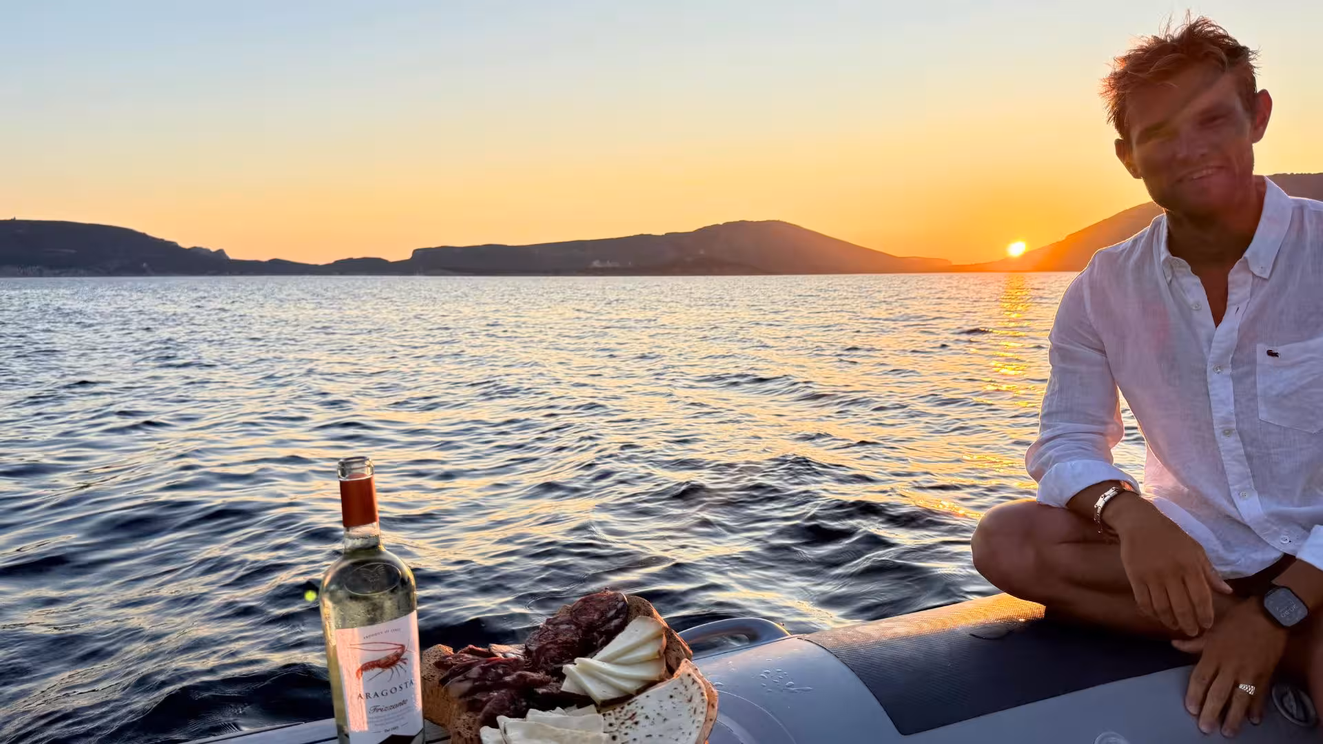 Private Alghero sunset dinghy tour with wine and cheese, offering scenic views and a relaxing experience on the water.