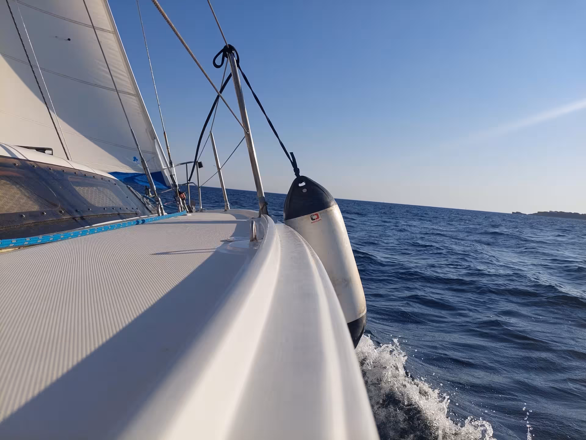 Sailboats silhouetted against a vibrant orange sunset in Alghero, perfect for a serene evening tour.