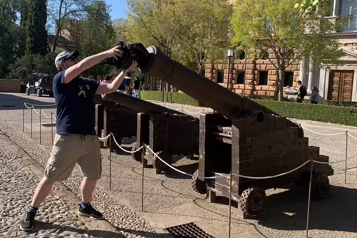 Traveler explores historic Alhambra cannons in Granada on a self-guided scavenger hunt walking tour