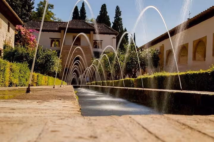 Stunning view of the Alhambra's Generalife gardens with arched water fountains, a highlight on the Andalusia tour.