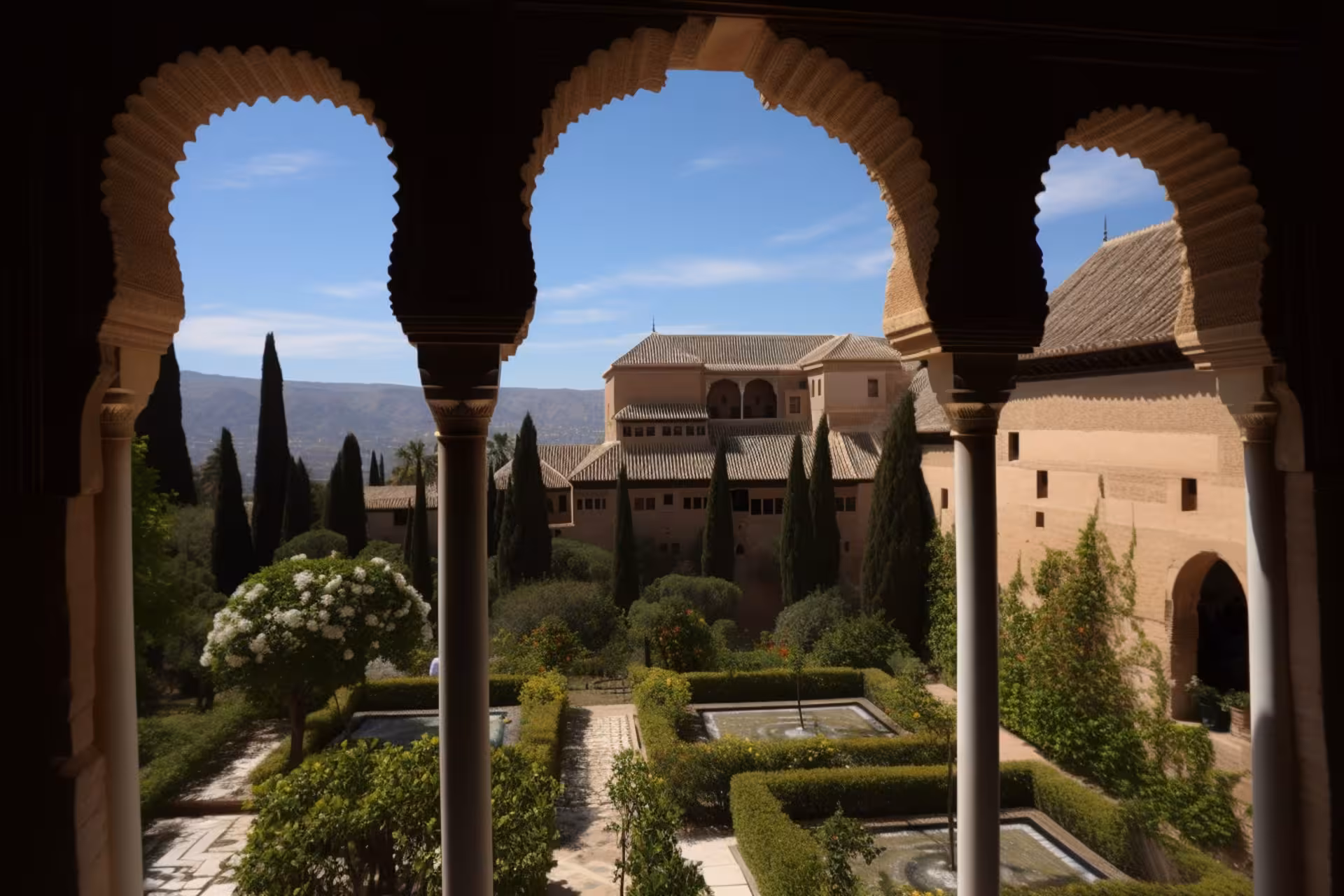 View of Alhambra's lush gardens and architectural beauty through ornate arches in Generalife.