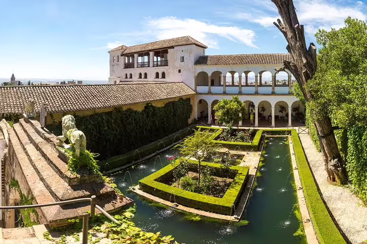 Scenic view of the Alhambra's lush Generalife gardens with historic architecture, perfect for cruise passengers visiting from Malaga.