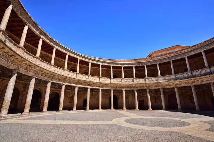 Stunning view of the Alhambra's circular courtyard under a clear blue sky, perfect for cruise passengers visiting from Malaga.