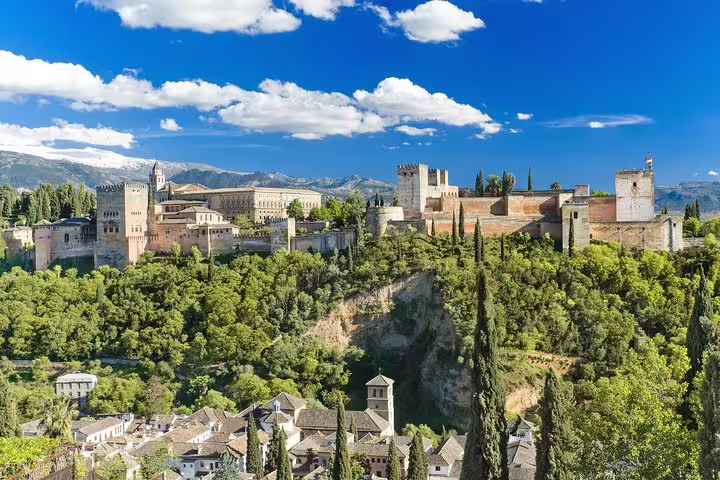 View of the Alhambra in Granada, surrounded by lush greenery and mountains, perfect for cruise passengers from Malaga Port.