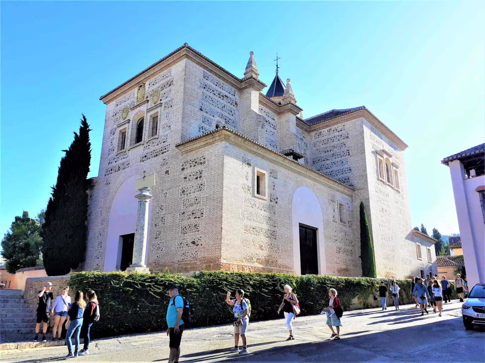 Alhambra group walking tour passing Iglesia de Santa Maria de la Alhambra, Granada sightseeing route