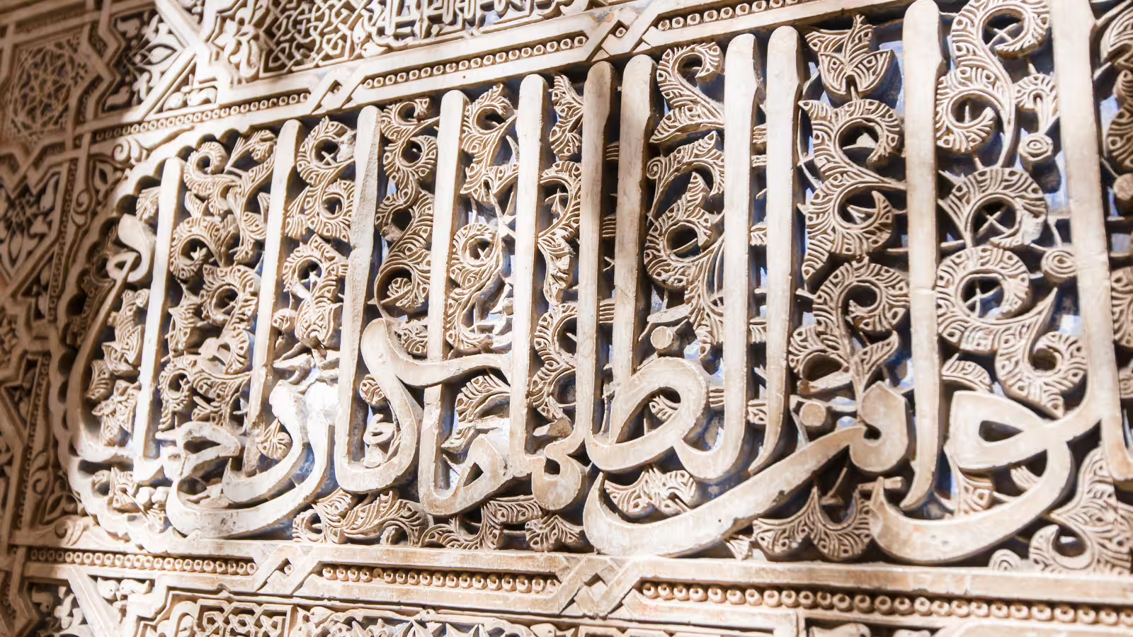 Close-up of Alhambra Nasrid Palace arabesque stucco and Arabic calligraphy, seen on guided walking tours