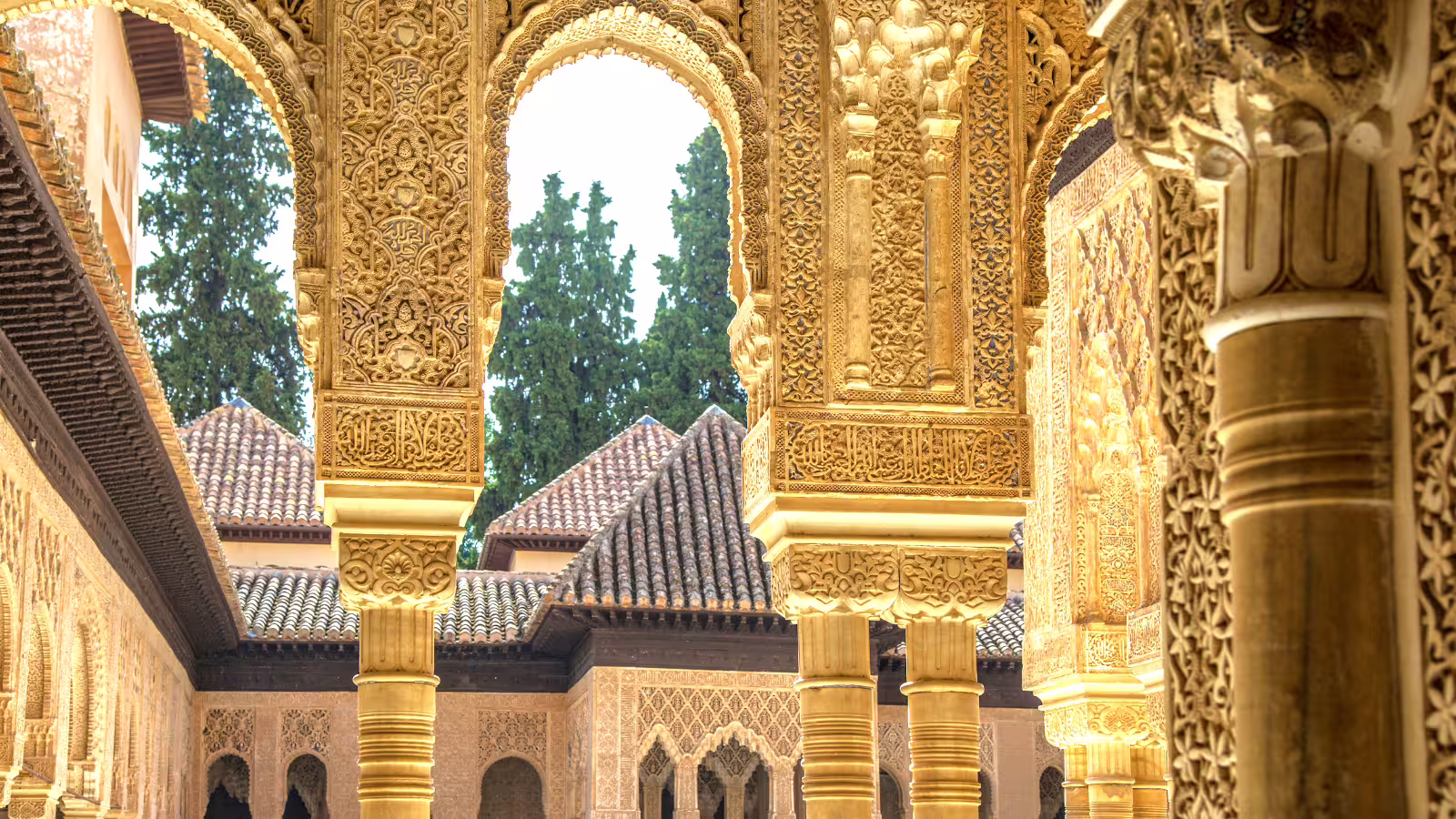 Alhambra group walking tour close-up of Nasrid palace arches and intricate stucco carvings in Granada, Spain