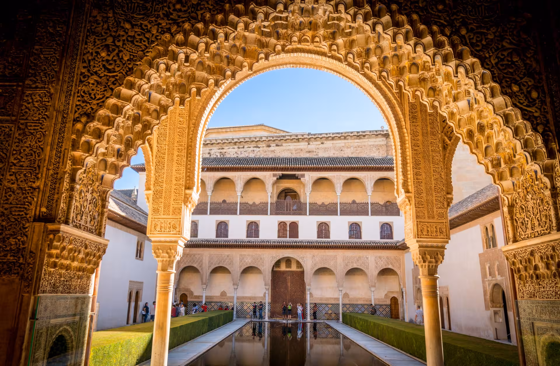 Stunning courtyard view through ornate archway in the Alhambra's Nasrid Palaces, highlighting Islamic design.