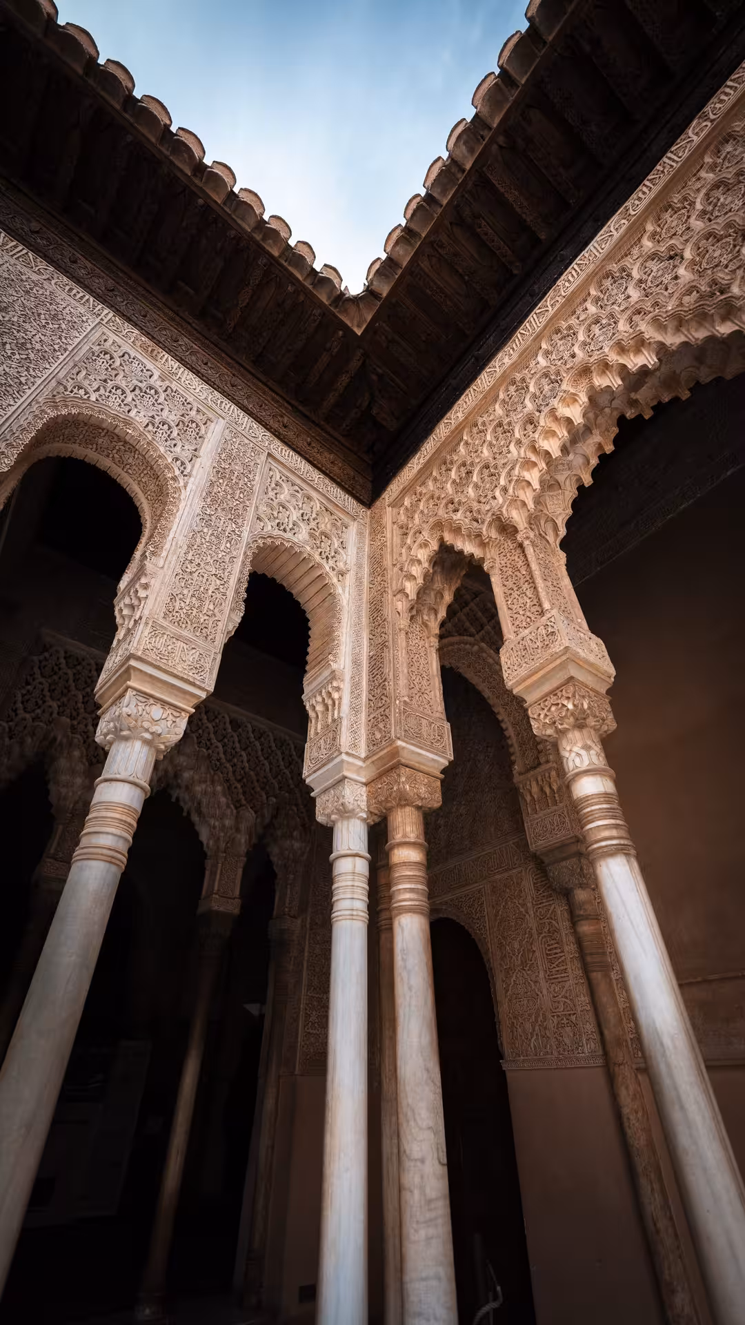 Intricate arches and columns of the Alhambra's Nasrid Palaces, showcasing exquisite Moorish architecture.