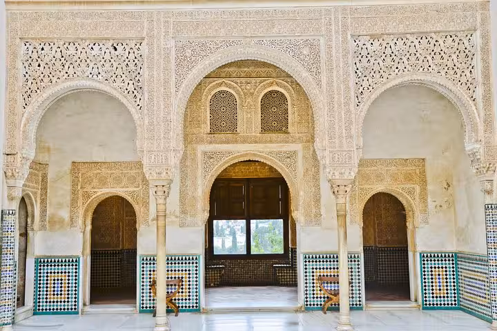 Intricate Moorish arches and tilework inside the historical Alhambra Palace in Granada, Andalusia.