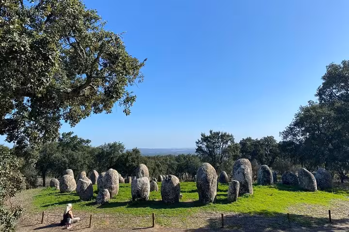 Discover the prehistoric Almendres Cromlech megalithic site surrounded by oak trees on the Évora Uncovered Tour.