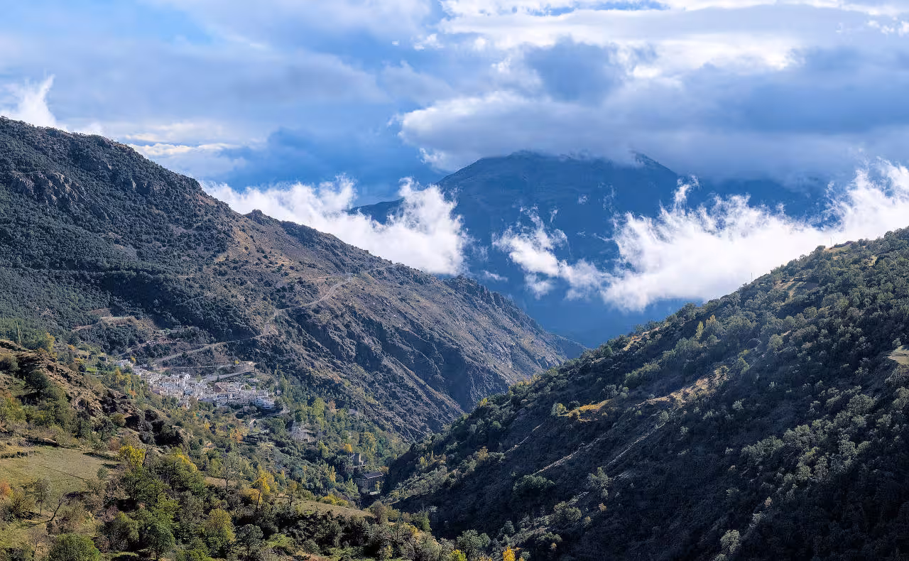 Breathtaking view of the Alpujarra mountains with clouds rolling over rugged terrain near Soportújar and Pampaneira.