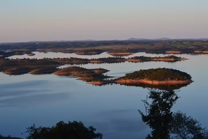 Breathtaking view of Alqueva Dam's serene waters and small islands at sunset, perfect for a peaceful escape.