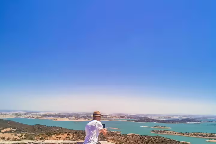 Traveler enjoying panoramic view of Alqueva Lake near Monsaraz during a day trip from Lisbon to Évora and Monsaraz.
