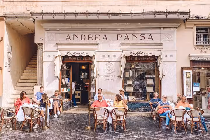 Visitors enjoying coffee at the historic Andrea Pansa café in Amalfi, capturing the essence of local culture on a tour.