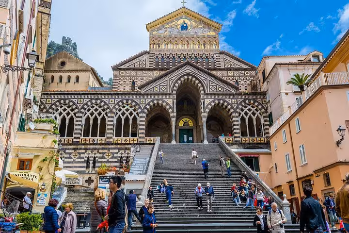 Vibrant Amalfi Cathedral with intricate architecture and bustling visitors on a sunny day, ideal for an Amalfi Coast tour.