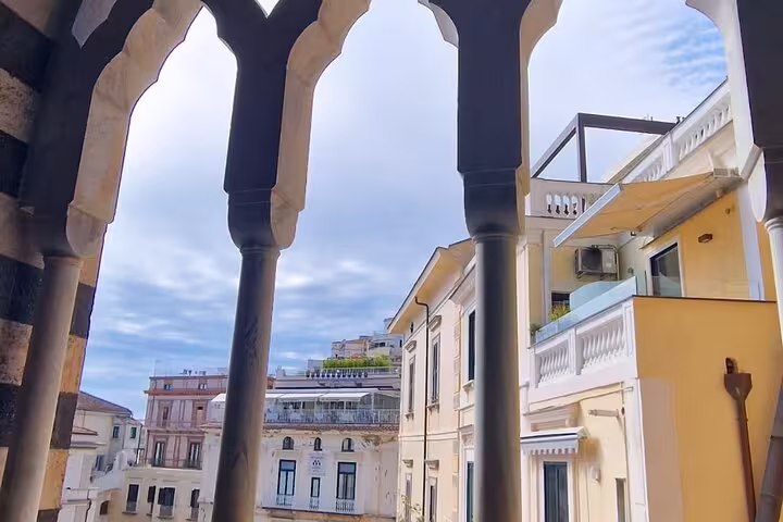 Scenic view of charming buildings in Amalfi, framed by elegant arches, on a private tour from Naples.