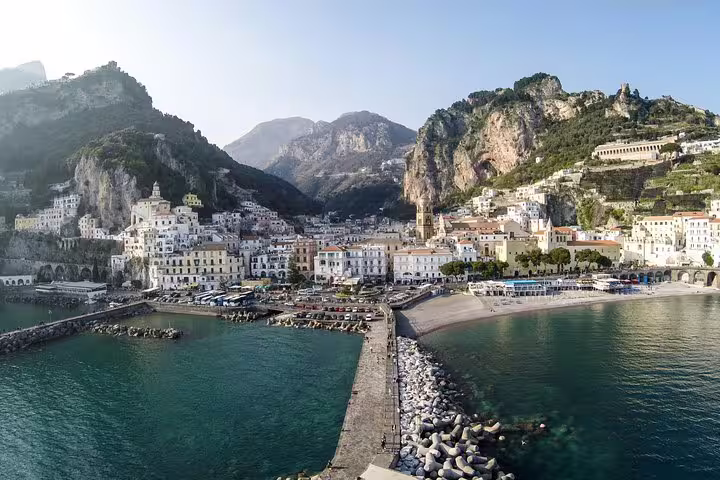 Aerial view of Amalfi town, colorful houses and marina beneath dramatic cliffs on a private full day Amalfi Coast tour