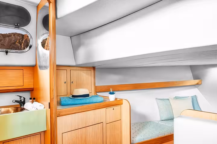 Luxurious cabin interior on a small-group boat tour along the Amalfi Coast, featuring cozy bedding and elegant wood finishes.