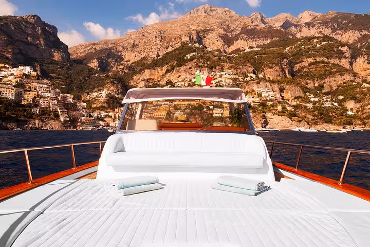 Luxurious boat deck with Amalfi Coast cliffs in the background, perfect for exclusive small-group tours.