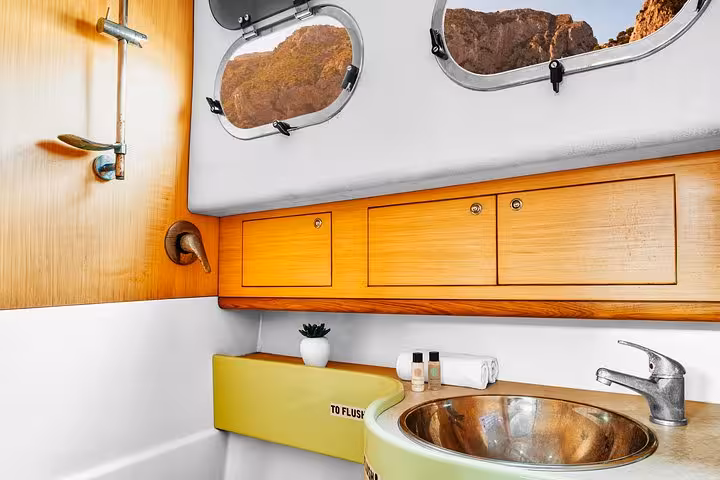 Modern bathroom amenities on a small-group boat tour along the Amalfi Coast, with scenic views through the portholes.
