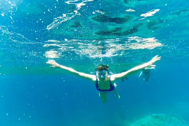 Snorkeler exploring the clear waters of the Amalfi Coast, a highlight of the full-day Bay of Ieranto boat tour.