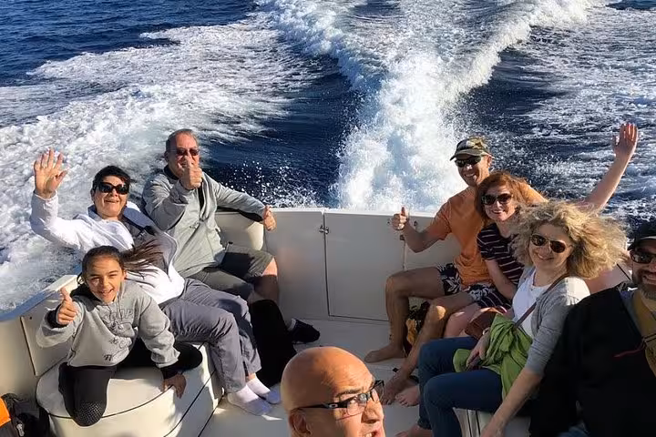 Group enjoying a thrilling boat ride on the Amalfi Coast during a full-day tour from Sorrento to Positano.