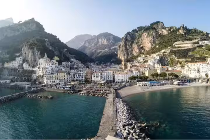 Panoramic view of Amalfi Coast harbor with colorful seaside village, marina and cliffs, ideal for Italy cruise shore excursion