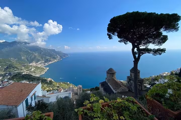 Breathtaking view of the Amalfi Coast with azure sea and lush greenery, perfect for a small-group minivan tour.