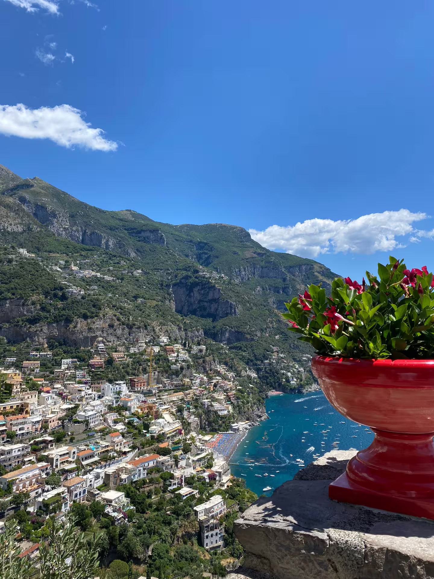 Amalfi Coast viewpoint over Positano bay with flower pot, highlight of Naples to Sorrento Amalfi Ravello tour