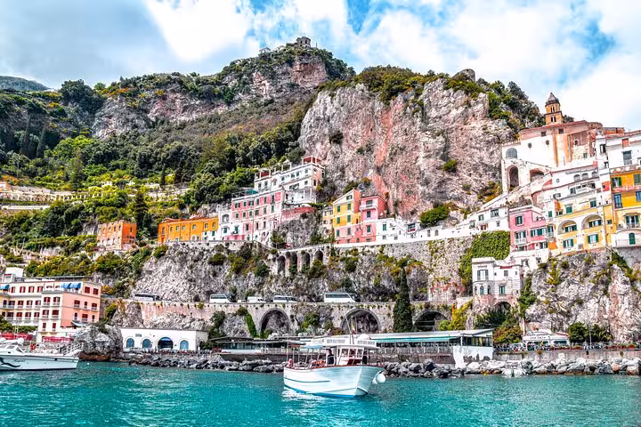 Colorful cliffside buildings overlooking the turquoise waters of the Amalfi Coast, perfect for a scenic Italian getaway.