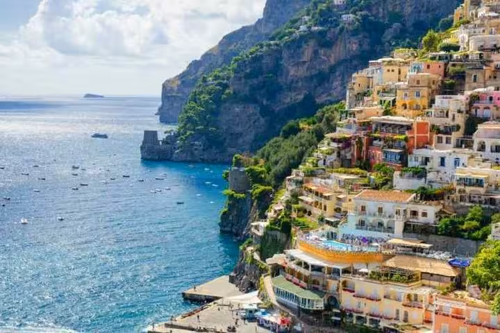 Scenic view of colorful cliffside houses in Positano overlooking the sparkling blue waters of the Amalfi Coast.