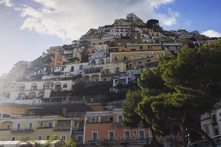Scenic view of colorful hillside buildings in Positano on the Amalfi Coast under a bright blue sky.
