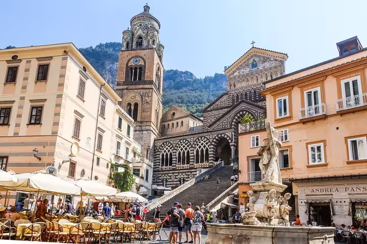 Charming Amalfi town square with historic cathedral, perfect for exploring on a Naples shore excursion.