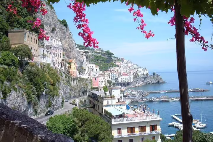 Colorful cliffside houses, marina and bougainvillea-framed sea views in Amalfi town on an exclusive Amalfi Coast shore tour