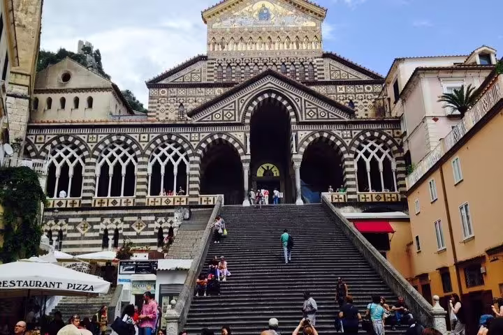 Visitors climb the grand staircase to Amalfi’s ornate Duomo cathedral on a guided Amalfi Coast private tour