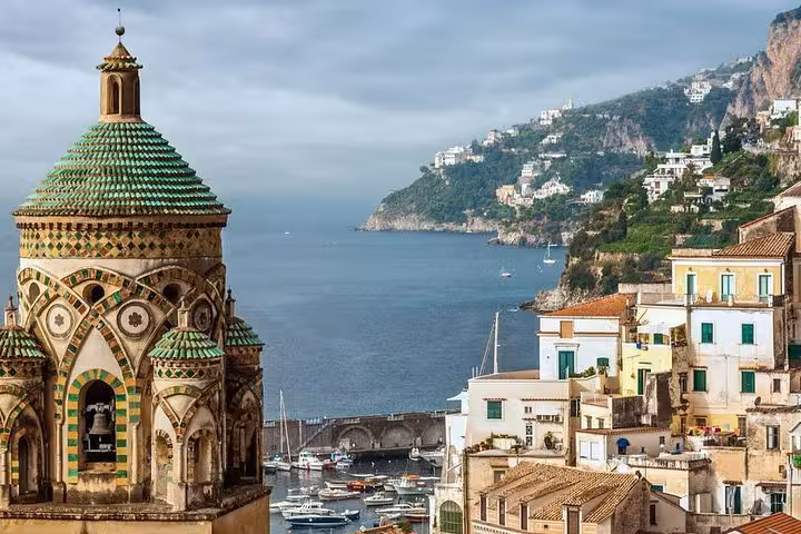 Stunning Amalfi coast view with vibrant historic architecture, overlooking the serene sea and lush green cliffs.