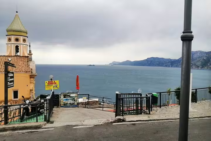 Scenic roadside viewpoint with church tower and sweeping sea vistas along Amalfi Coast on shared tour Ravello Amalfi Positano