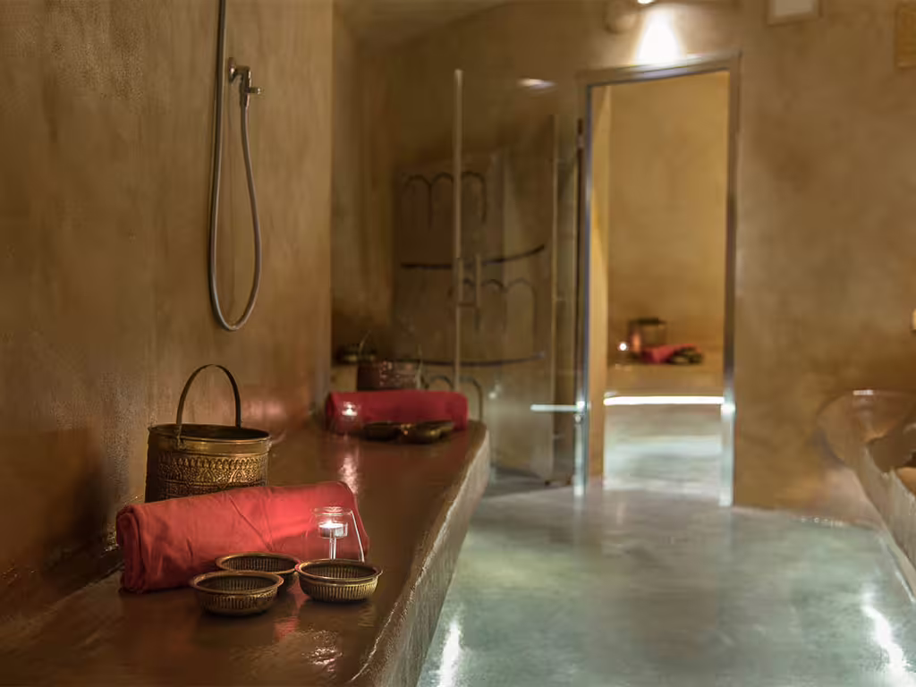 Intimate Amalfi Coast spa hammam with warm lighting, red towels and brass bowls ready for a romantic wellness ritual