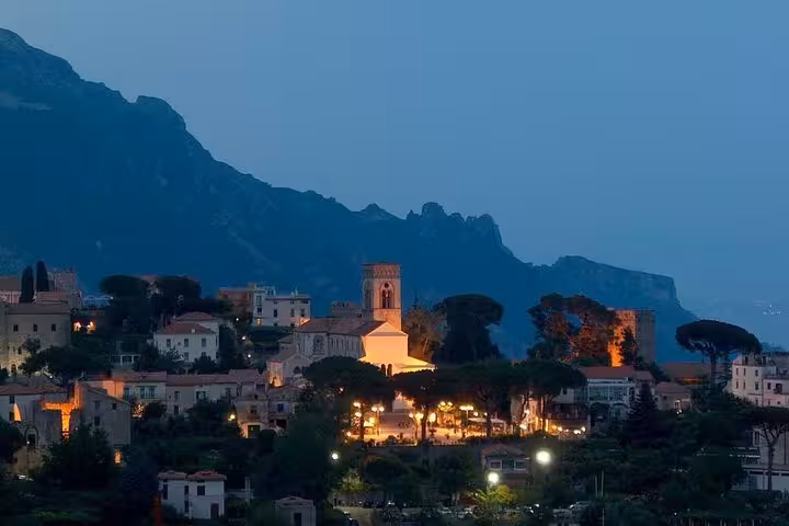 Evening lights highlight a quaint village nestled in the hills of the Amalfi Coast, ideal for scenic night tours.